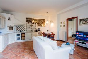uma sala de estar com um sofá branco e uma cozinha em La Suite del Castello em Belgirate