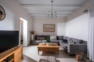 un soggiorno con divano e TV di Kallisti Natural Villa a Kalamaki