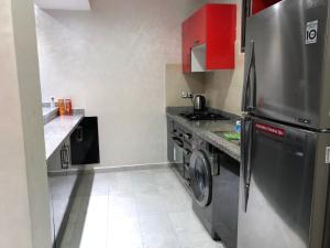 eine Küche mit einem Kühlschrank und einer Waschmaschine in der Unterkunft Appartement de vacances piscine in Mohammedia