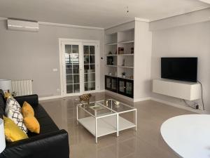 a living room with a black couch and a tv at SeaMed in Málaga