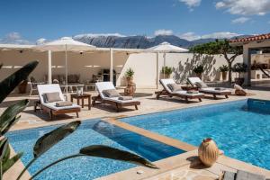 una piscina con tumbonas y una piscina en Kallisti Natural Villa, en Kalamaki