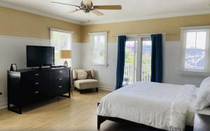a bedroom with a bed and a television and a chair at Ballard's Beach Resort in New Shoreham