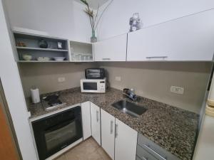 una pequeña cocina con fregadero y microondas en Cómodo monoambiente en Palermo cama King Seguridad 24 h en Buenos Aires