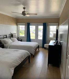 a bedroom with two beds and a flat screen tv at Ballard's Beach Resort in New Shoreham