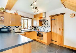 a kitchen with wooden cabinets and a counter top at Crud y Werin in Llandderfel