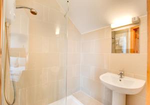a white bathroom with a sink and a shower at Crud y Werin in Llandderfel +15 photos