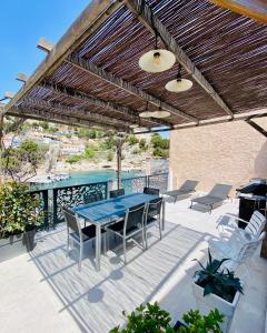 un patio avec une table bleue et des chaises sur une terrasse dans l'établissement Villa La calanquaise, à Le Rove