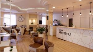 um átrio de um restaurante com mesas e cadeiras em Hotel Venezuela em Lido di Jesolo