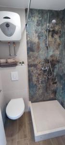 y baño con ducha, aseo y lavamanos. en Rooms Lucky, en Makarska