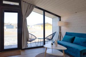 ein Wohnzimmer mit einem blauen Sofa und einem Tisch in der Unterkunft SKAN-PARK Ferienhäuser & Tiny Houses am Bärwalder See 