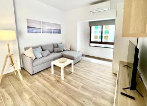 a living room with a couch and a tv at Benidorm Old Town House with lounge area in Benidorm