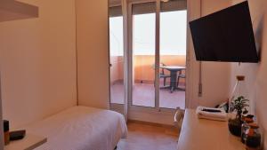 1 dormitorio con cama y vistas a un balcón en Hotel Venezuela, en Lido di Jesolo