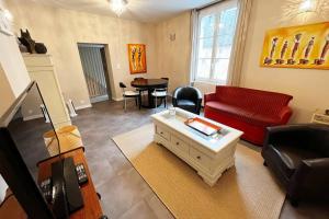 ein Wohnzimmer mit einem roten Sofa und einem Tisch in der Unterkunft #Le Maillard #Grand F2 #Hyper Centre in Brive-la-Gaillarde