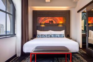 sypialnia z dużym łóżkiem z czerwoną ławką w obiekcie Aloft Philadelphia Downtown w Filadelfii