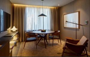 a living room with a dining room table and chairs at Fasano Sao Paulo Itaim in Sao Paulo