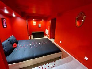 um quarto com paredes vermelhas e uma cama com flores em Le CinéGlam Spa em Margny-lès-Compiègne