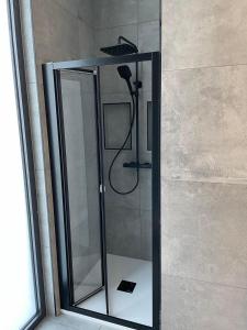 un bagno con doccia e porta in vetro di PRIMÁTOR CAMPING RESORT LITOMYŠL a Litomyšl