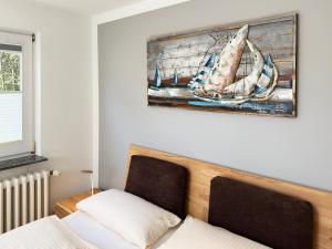 una camera da letto con un letto e un dipinto sul muro di Haus *Üüs Aran* Wohnung Nr. 2 a Wittdün