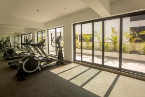 einen Fitnessraum mit Laufbändern und Crosstrainern in einem Zimmer mit Fenstern in der Unterkunft SoHo by Wynwood House in Lima