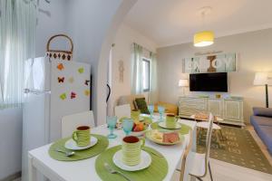 a kitchen and living room with a table with dishes on it at Bambus House Green in Quarteira