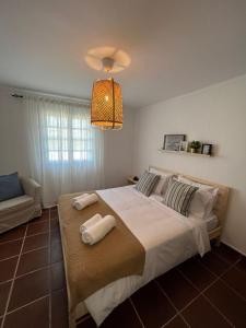 - une chambre avec un grand lit et 2 serviettes dans l'établissement Coast Beach Apartment - Praia da Areia Branca, à Praia da Areia Branca
