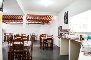 a restaurant with wooden tables and chairs and a counter at Pousada Valmar in Aracaju
