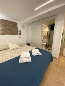 a bedroom with a blue bed with towels on it at Casa Matì in Altedo