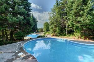 a swimming pool in a yard with trees at Serenity Peaks Lodge by InstantSuites-LaBete Golf in Mont-Tremblant
