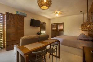 - une chambre avec un lit, une table et un canapé dans l'établissement Wayuum Suites Cozumel Oasis in Paradise, à Cozumel