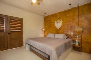 ein Schlafzimmer mit einem Bett und einer Holzwand in der Unterkunft Wayuum Suites Cozumel Oasis in Paradise in Cozumel + 19 Fotos