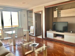 a living room with a table and a television at Apartamentos Azafranal-PARKING GRATIS- in Salamanca