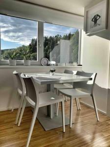 un tavolo bianco e sedie in una stanza con una finestra di Horský apartmán s výhledem na Lysou horu a Rokytnice nad Jizerou