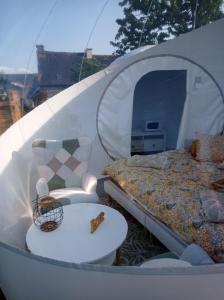a tent with a bed and a table and a chair at Hé Ma Bulle in Pleugueneuc +19 photos