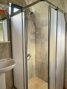 una ducha con una puerta de cristal junto a un lavabo en El-Ya Bungalov ve pansiyon, en Dalaman