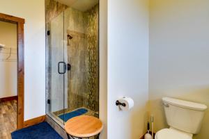 a bathroom with a shower with a toilet and a stool at Sleek Red Lodge Home Rental with Private Hot Tub! in Red Lodge +24 photos