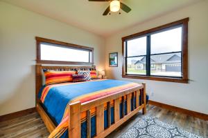 a bedroom with a wooden bed and two windows at Sleek Red Lodge Home Rental with Private Hot Tub! in Red Lodge