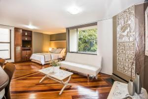 sala de estar con cama y sofá en Lloyds Apartasuites Parque 93, en Bogotá