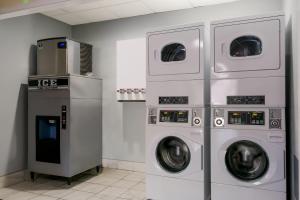 lavadero con 3 lavadoras y microondas en HomeTowne Studios by Red Roof Denver, PA en Denver