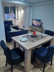 a dining room with a table and blue chairs at Apartments Josif in Gevgelija