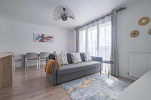 a living room with a couch and a table at Coco - Appartement F4 à 10 minutes de Disneyland Paris in Bailly-Romainvilliers