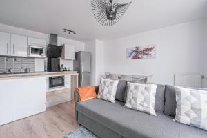 a living room with a couch and a kitchen at Coco - Appartement F4 à 10 minutes de Disneyland Paris in Bailly-Romainvilliers