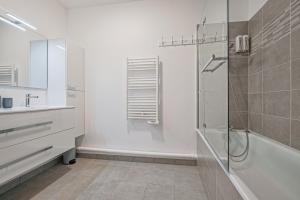a bathroom with a shower and a sink and a tub at Coco - Appartement F4 à 10 minutes de Disneyland Paris in Bailly-Romainvilliers +8 photos