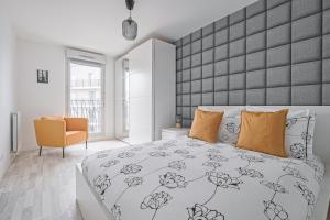 a bedroom with a large bed with orange pillows at Coco - Appartement F4 à 10 minutes de Disneyland Paris in Bailly-Romainvilliers