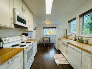 a kitchen with white appliances and a table in it at Phinneywood Cottage - Greenlake - Zoo - Phinney in Seattle
