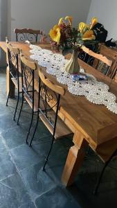 un tavolo in legno con sedie e un vaso di fiori sopra di Pousada Plantar e Cuidar a Santa Cruz do Escalvado