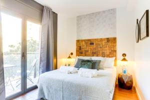 1 dormitorio con 1 cama blanca grande y balcón en Sweet Inn - Raul, en Barcelona