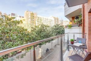 Un balcón con una mesa y dos gatos. en Sweet Inn - Raul, en Barcelona