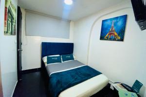 a small bedroom with a bed with a picture of the eiffel tower at Hotel Bogota Home in Bogotá