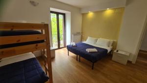 Poggio NativoB&B In Sabina的一间卧室配有一张床、一张床和一个窗户。 更多37张照片