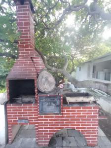 a brick oven with a tree in the background at Chácara da Bel in Pitimbu